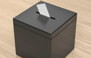 A ballot box with a white ballot partially inserted into the slot.